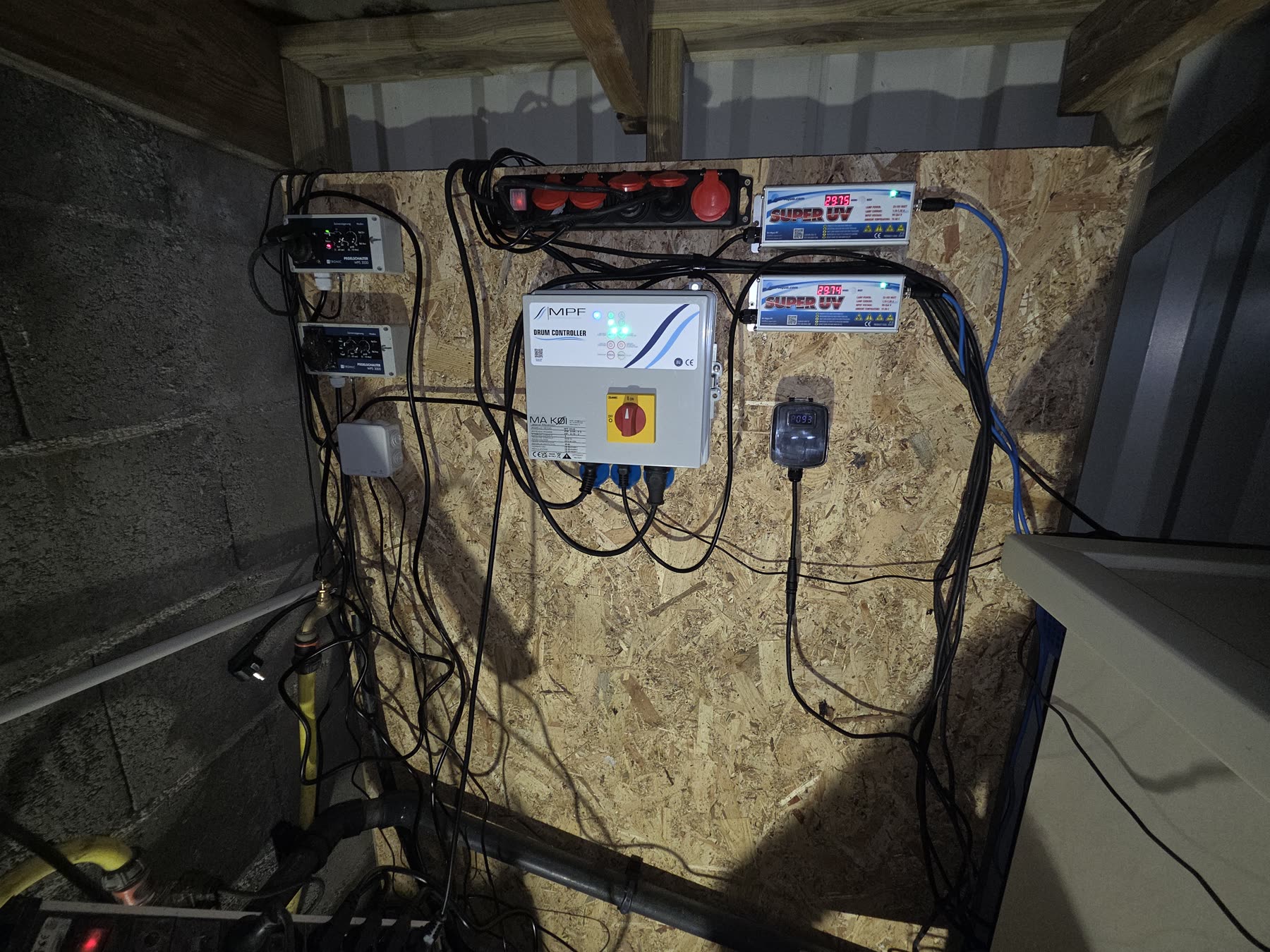 Un local technique de bassin: filtres, pompes, tableau électrique, tuyauterie